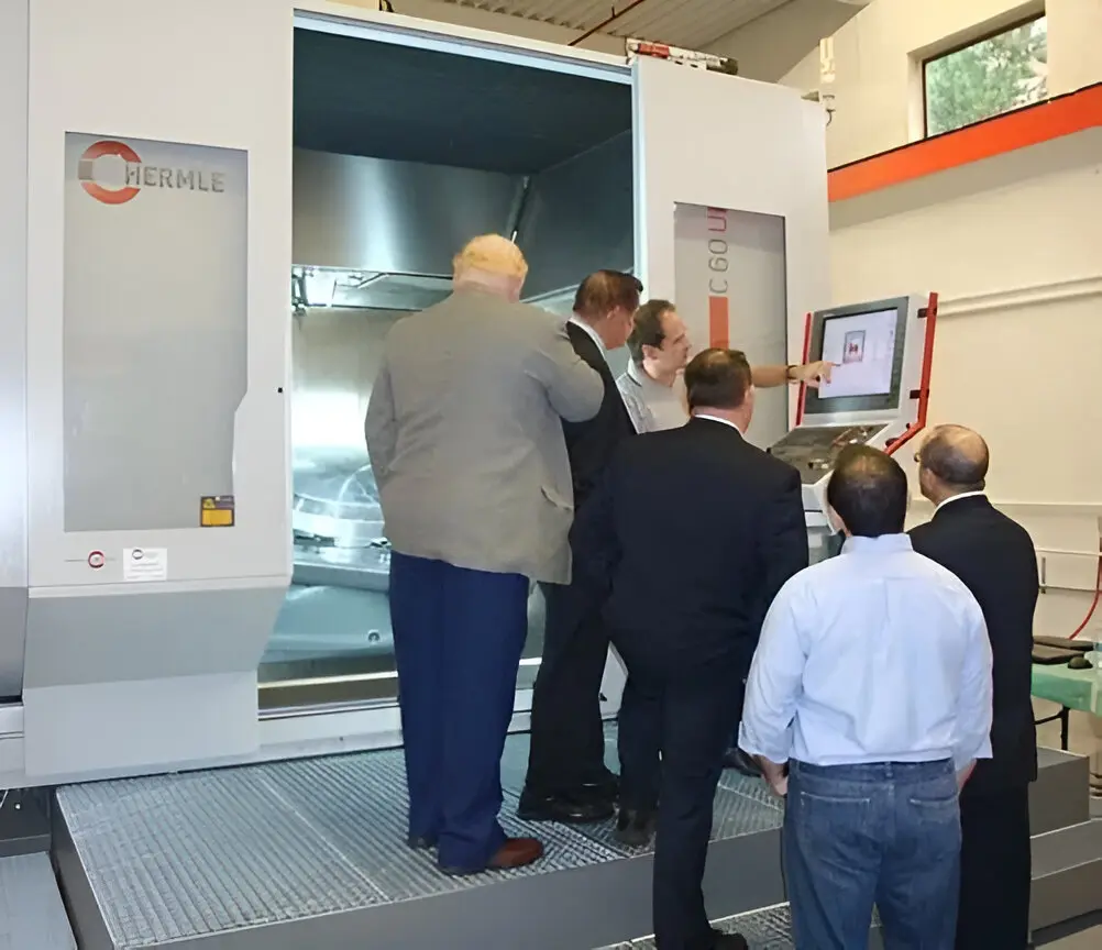 A group of people standing around in front of an industrial machine.