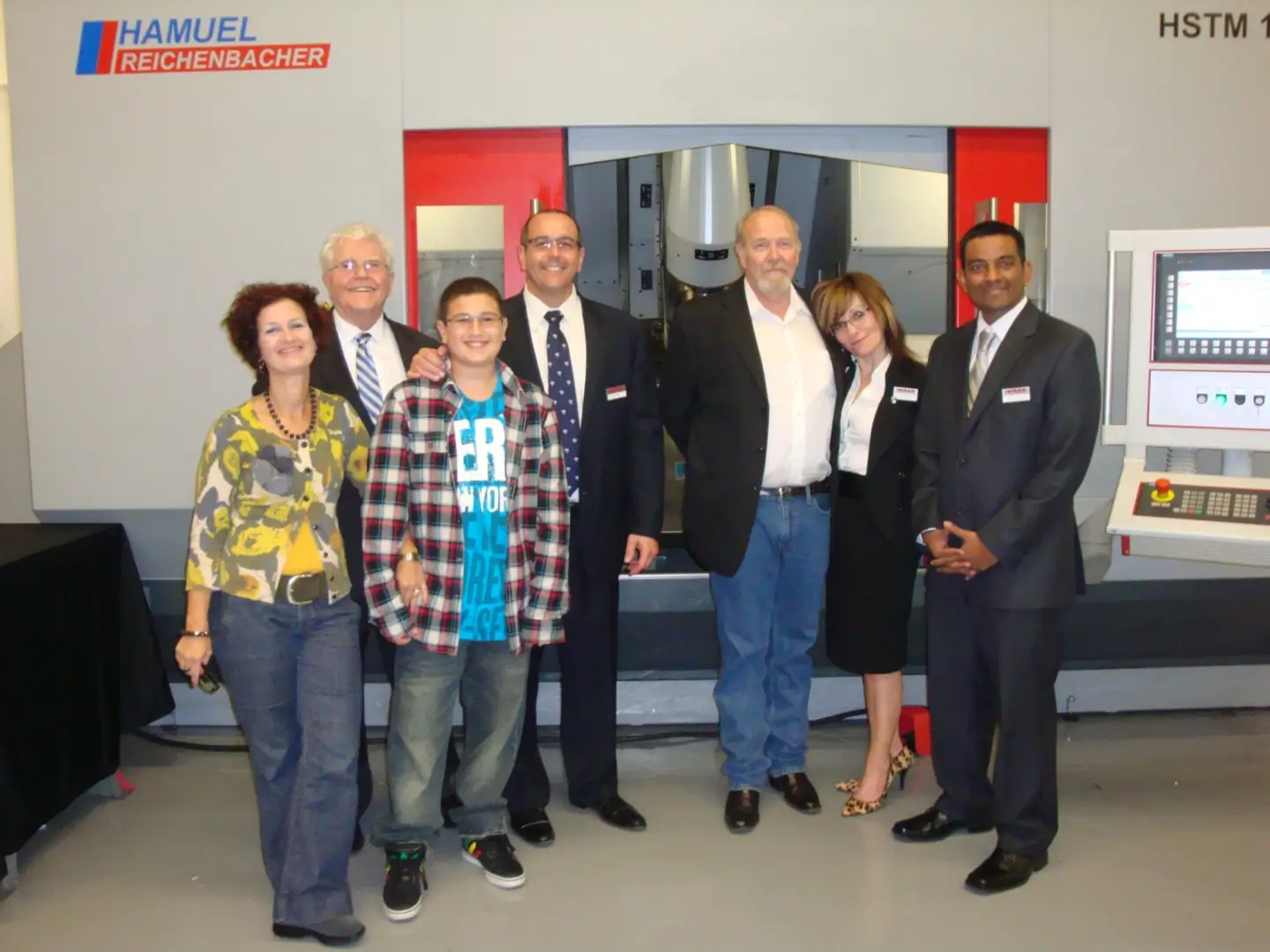 Group portrait in front of industrial machinery.